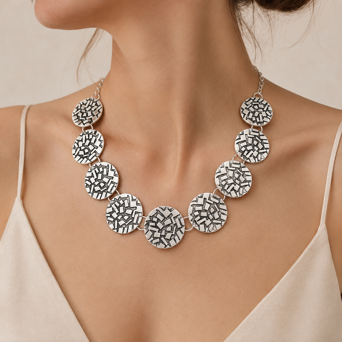 Silver round disc necklace shown from the front on a white background.
