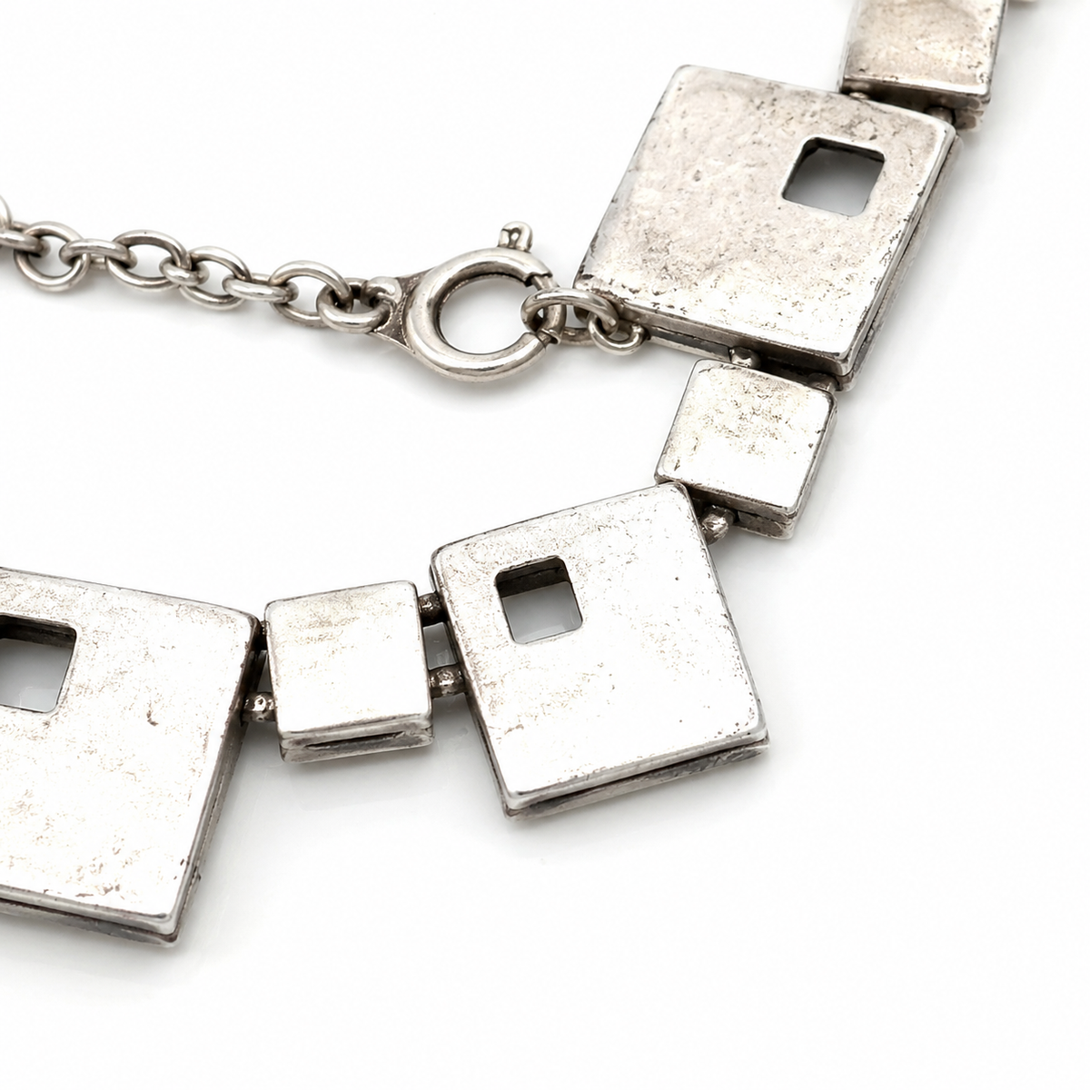 Close view of the square link details and textured silver-tone finish.