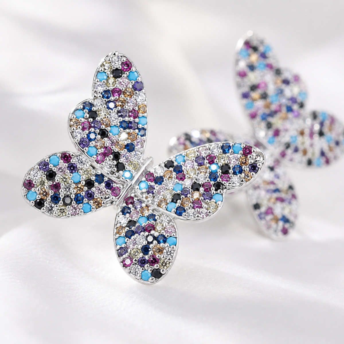 Close view of butterfly earrings with clustered multicolor CZ sparkle.