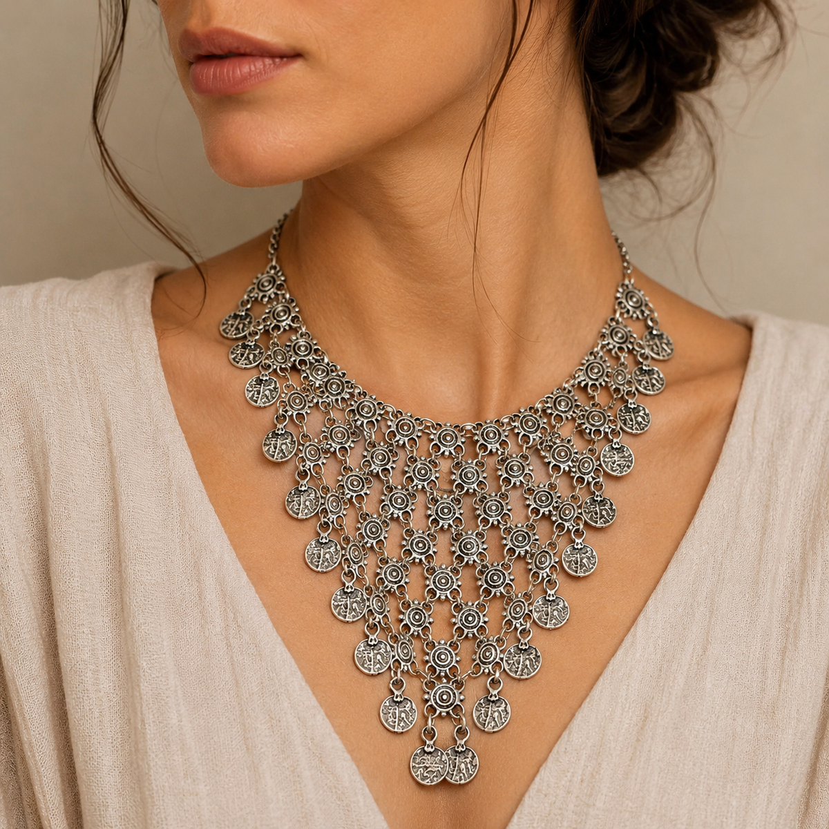 Silver-tone necklace with layered coin charms arranged in a bold statement shape.