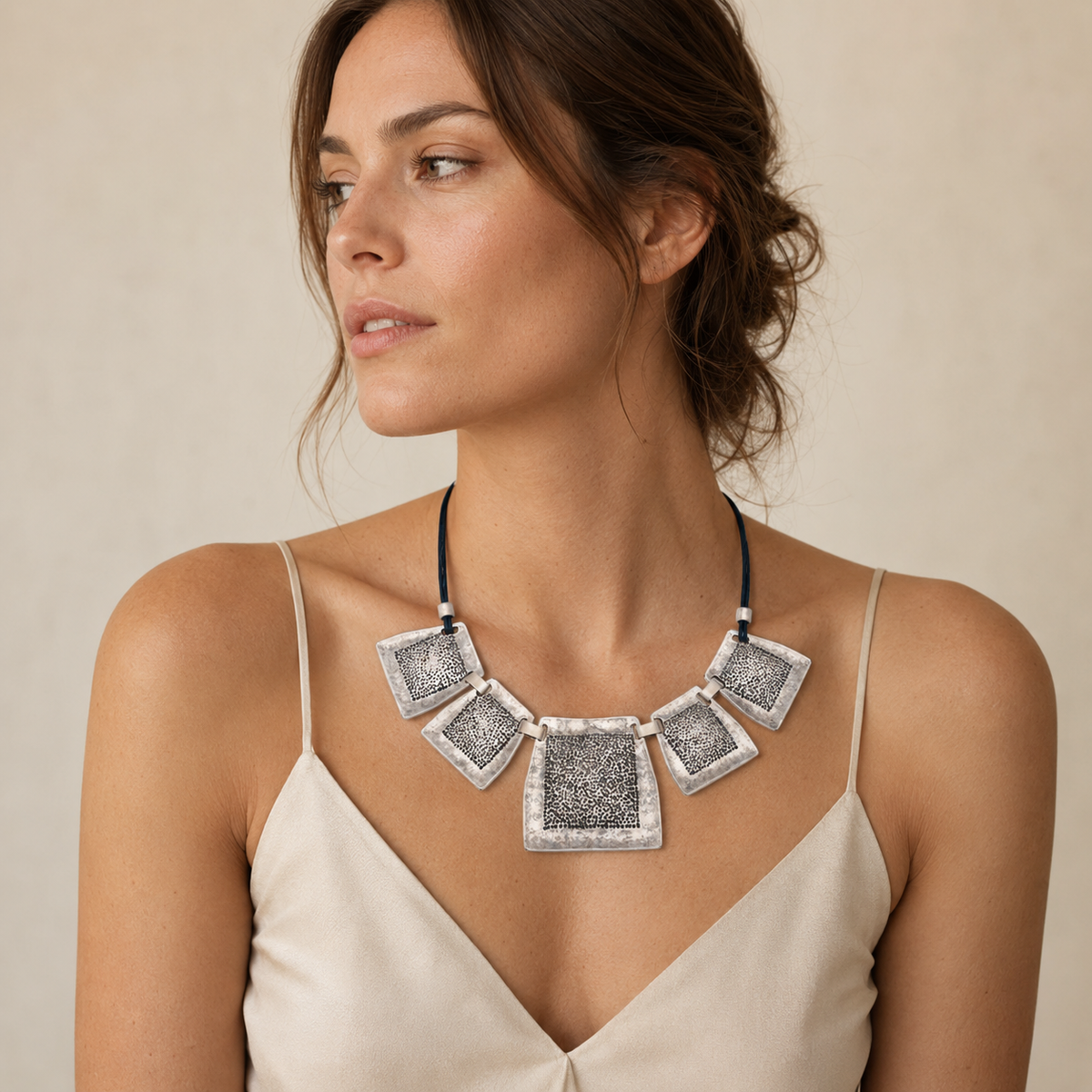 Textured square plate necklace with bold geometric pendant shapes.