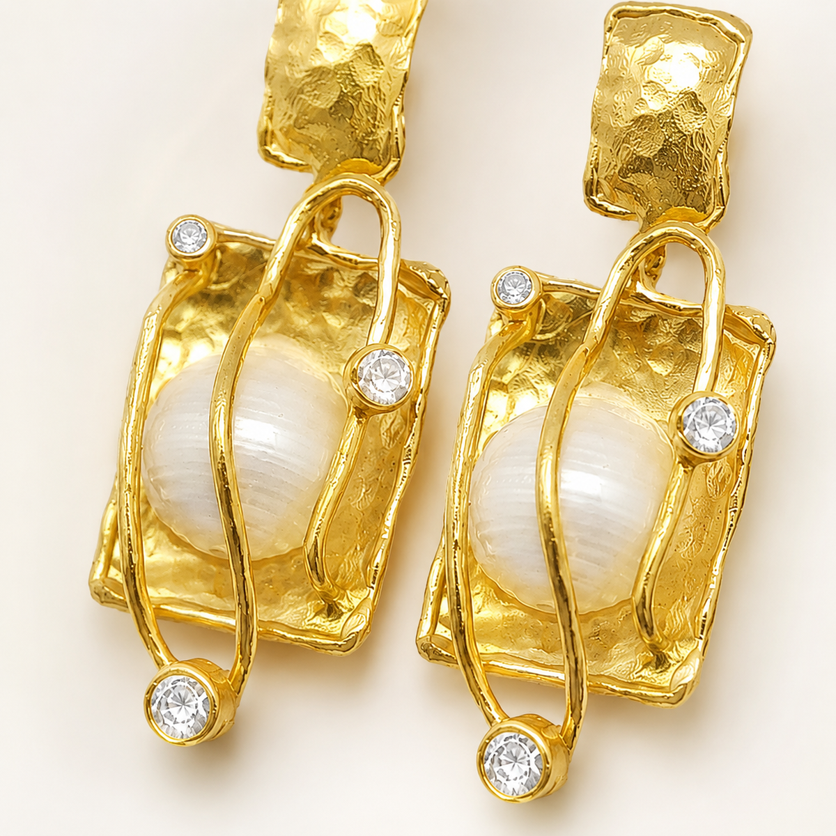 Close view of the textured gold-plated frame and pearl center.