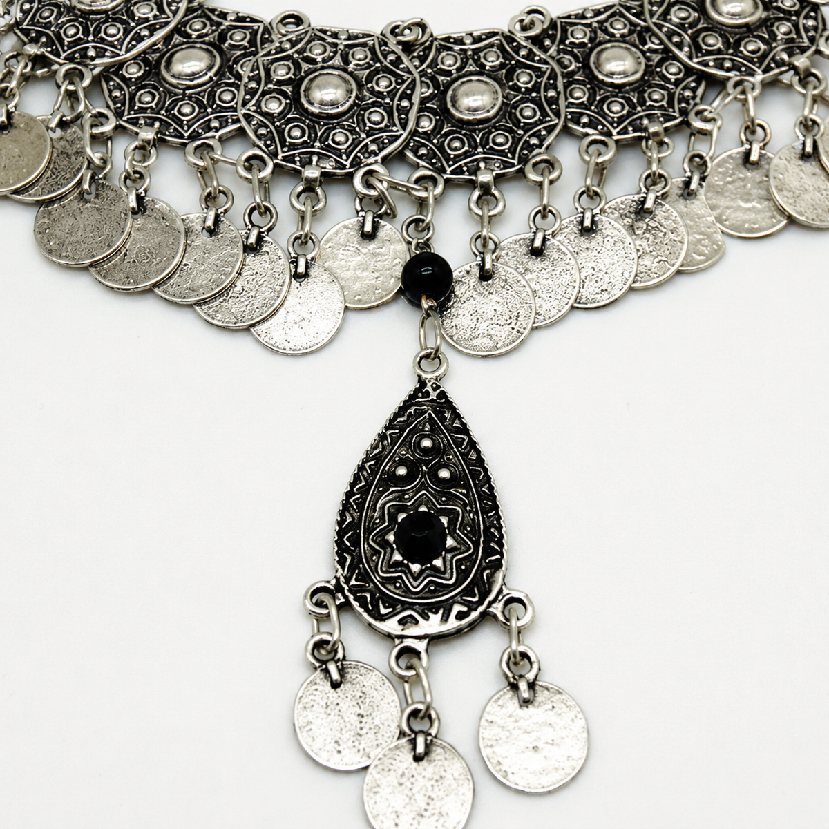 Close view of the black stone center and textured coin fringe.