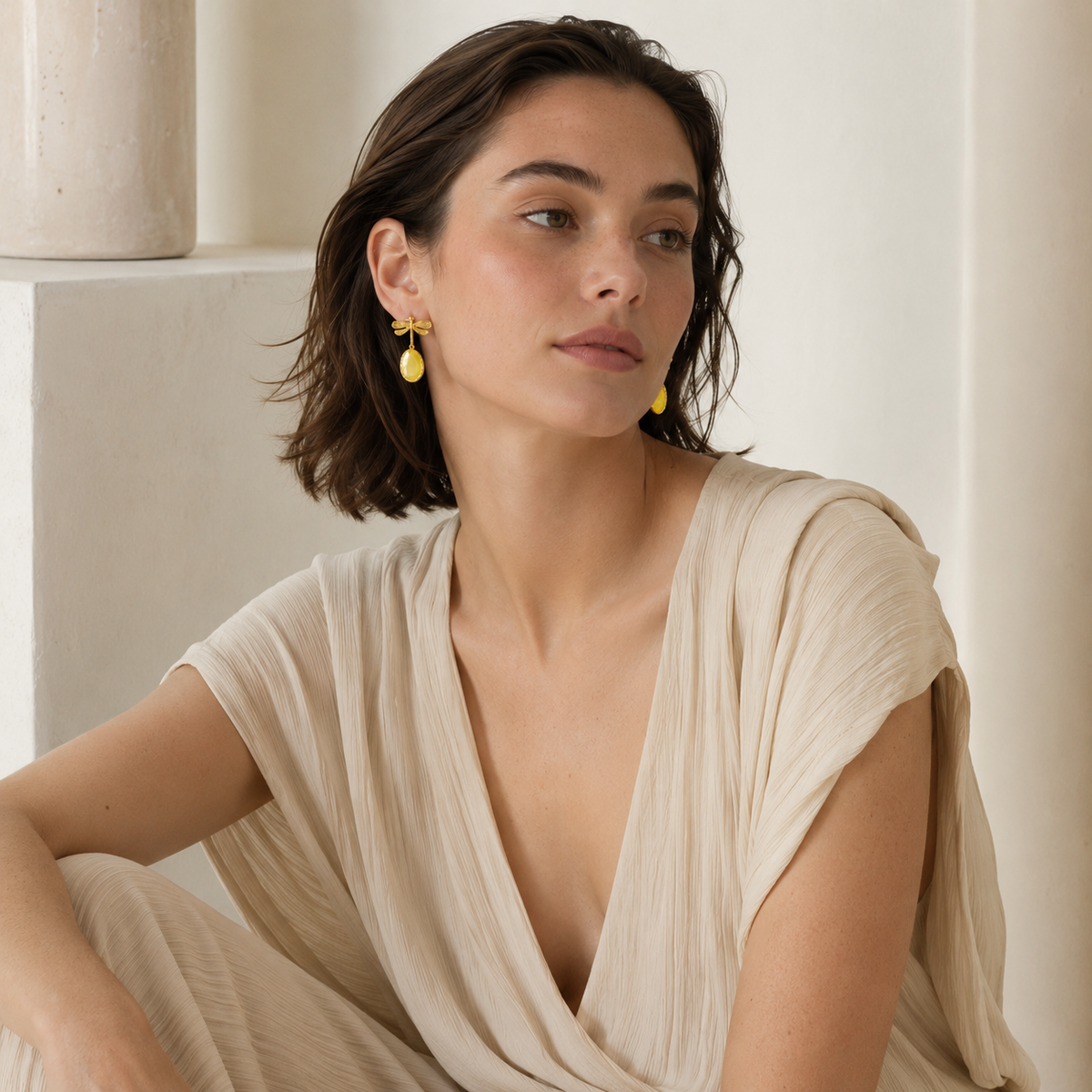 Dragonfly drop earrings in a gold finish with oval yellow accents.