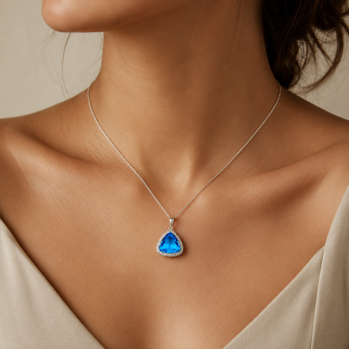 Triangle pendant necklace with a baby blue faceted stone and silver-tone chain.