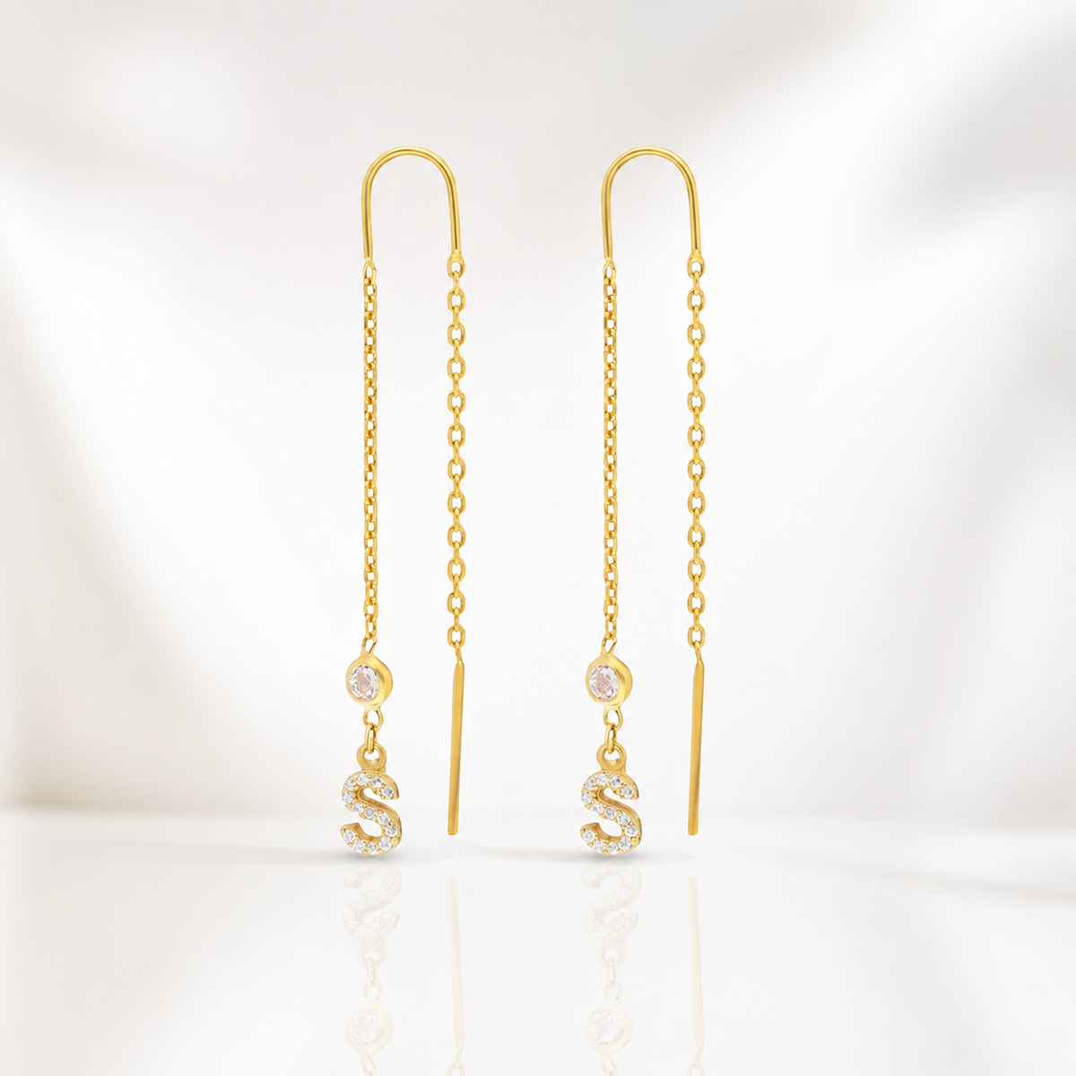 Gold-tone chain dangle earrings with a CZ-accented initial charm.