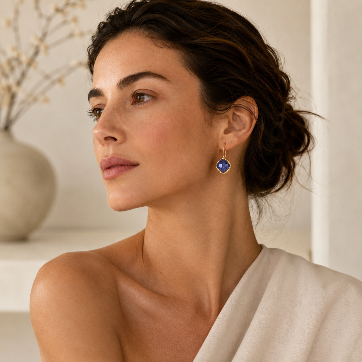 Blue sapphire dangle earrings with a gold-plated frame in a clean product view.