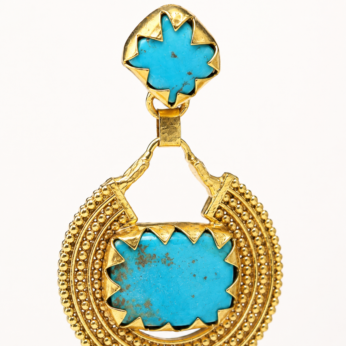 Close view of turquoise square stones set in gold-plated earrings.