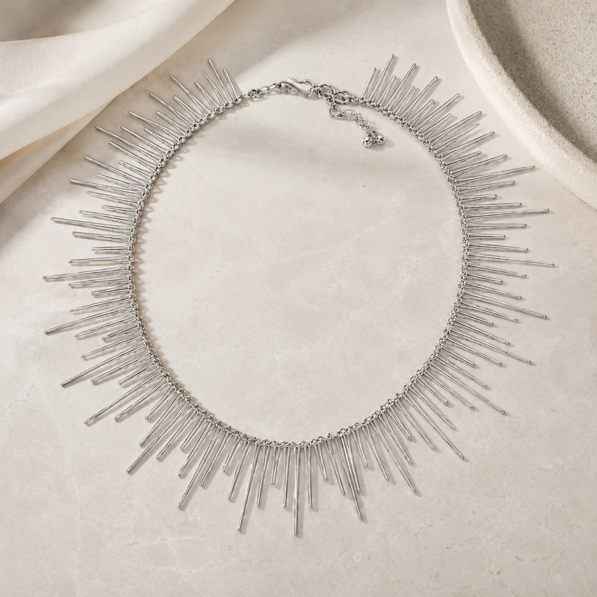 Silver-tone long spike collar necklace with a sculptural, modern shape.
