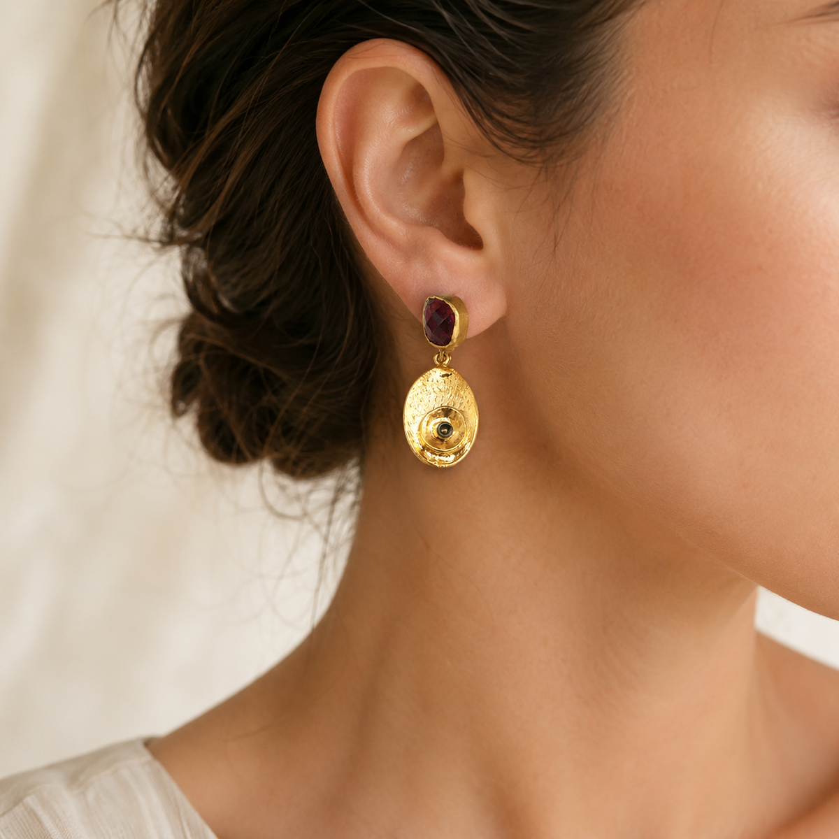 Gold-plated drop earrings with olive green stones shown from the front.