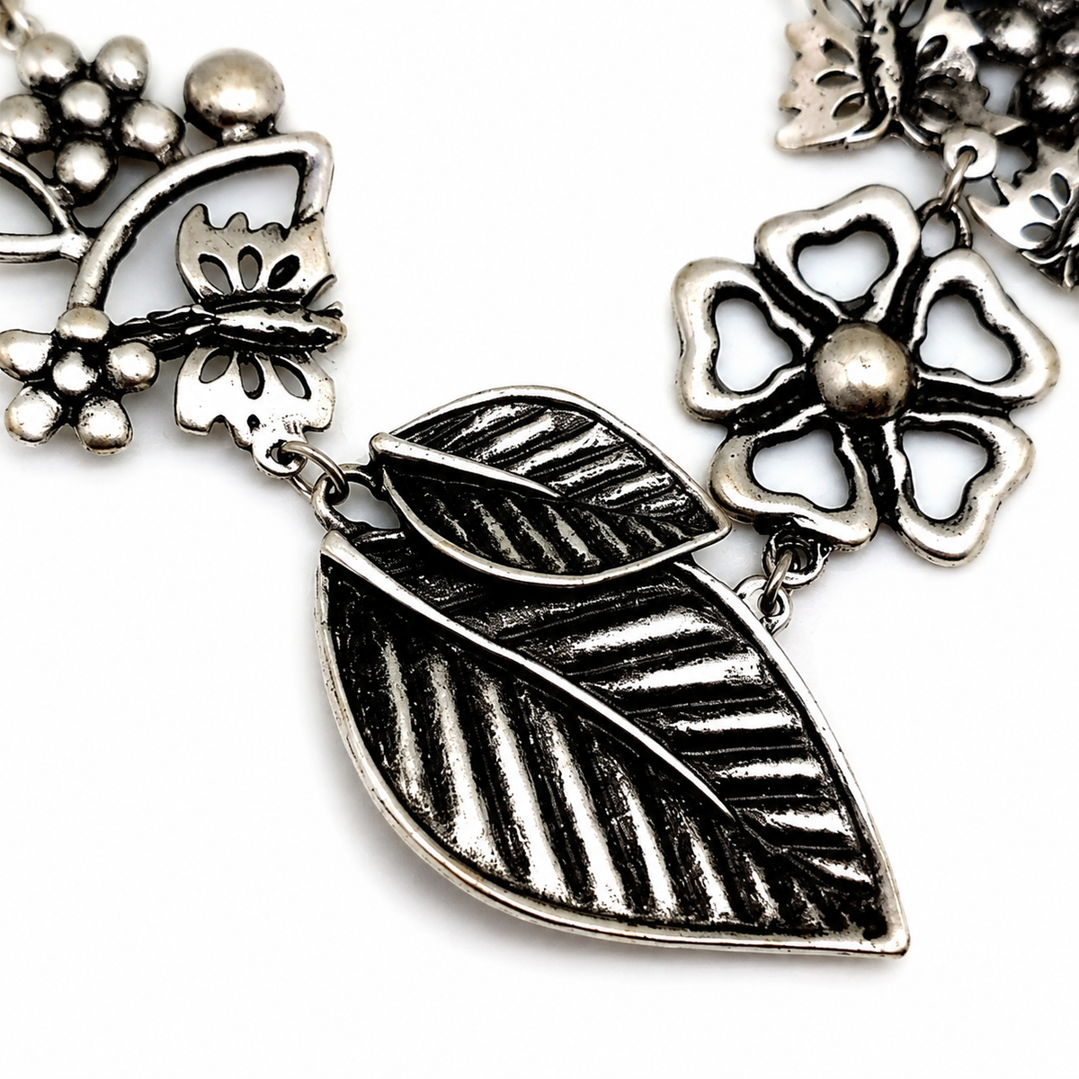Close view of the textured floral and leaf charm details.