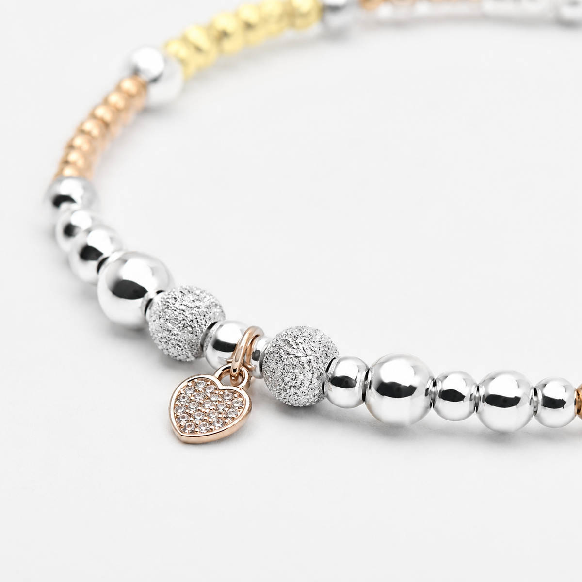Close view of the bracelet’s bead texture and heart charm detail.