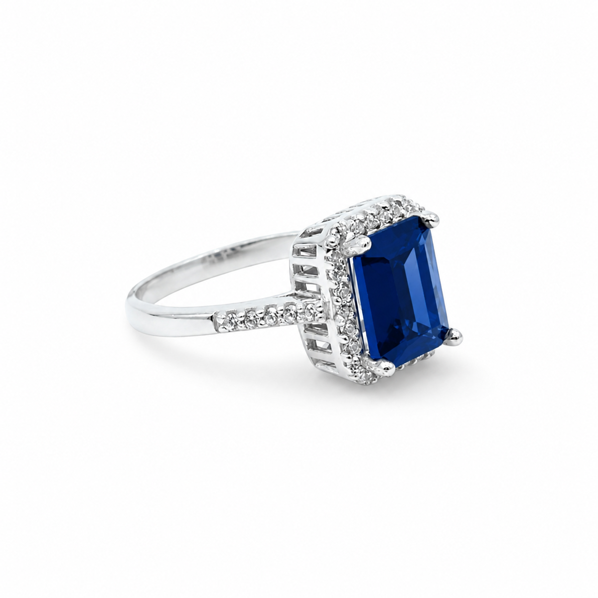 Cushion cut blue sapphire ring with a silver-tone setting and sparkling accents.