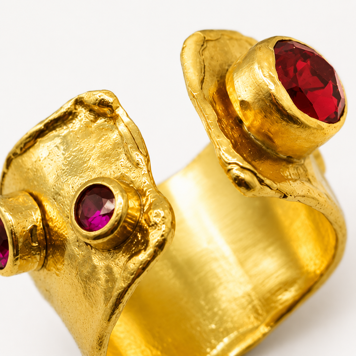 Close view of the textured gold-plated ring and garnet red stone details.