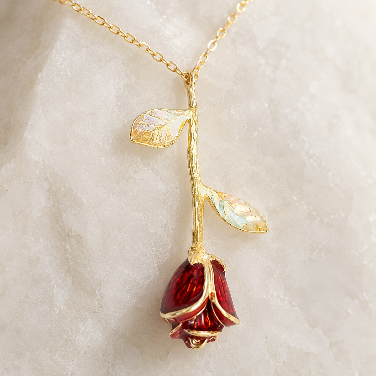 Close view of the red rose pendant and leaf accents.