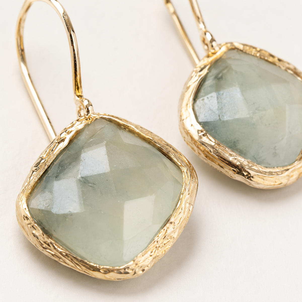Pair of green aventurine drop earrings with a gold-plated frame shown from the front.