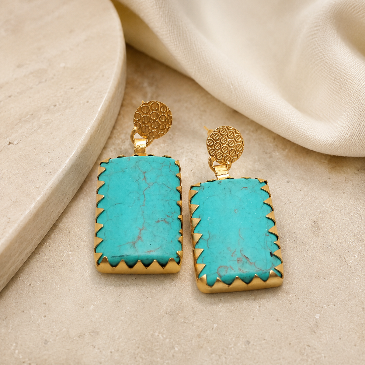 Gold-plated turquoise square earrings with a bold geometric shape.