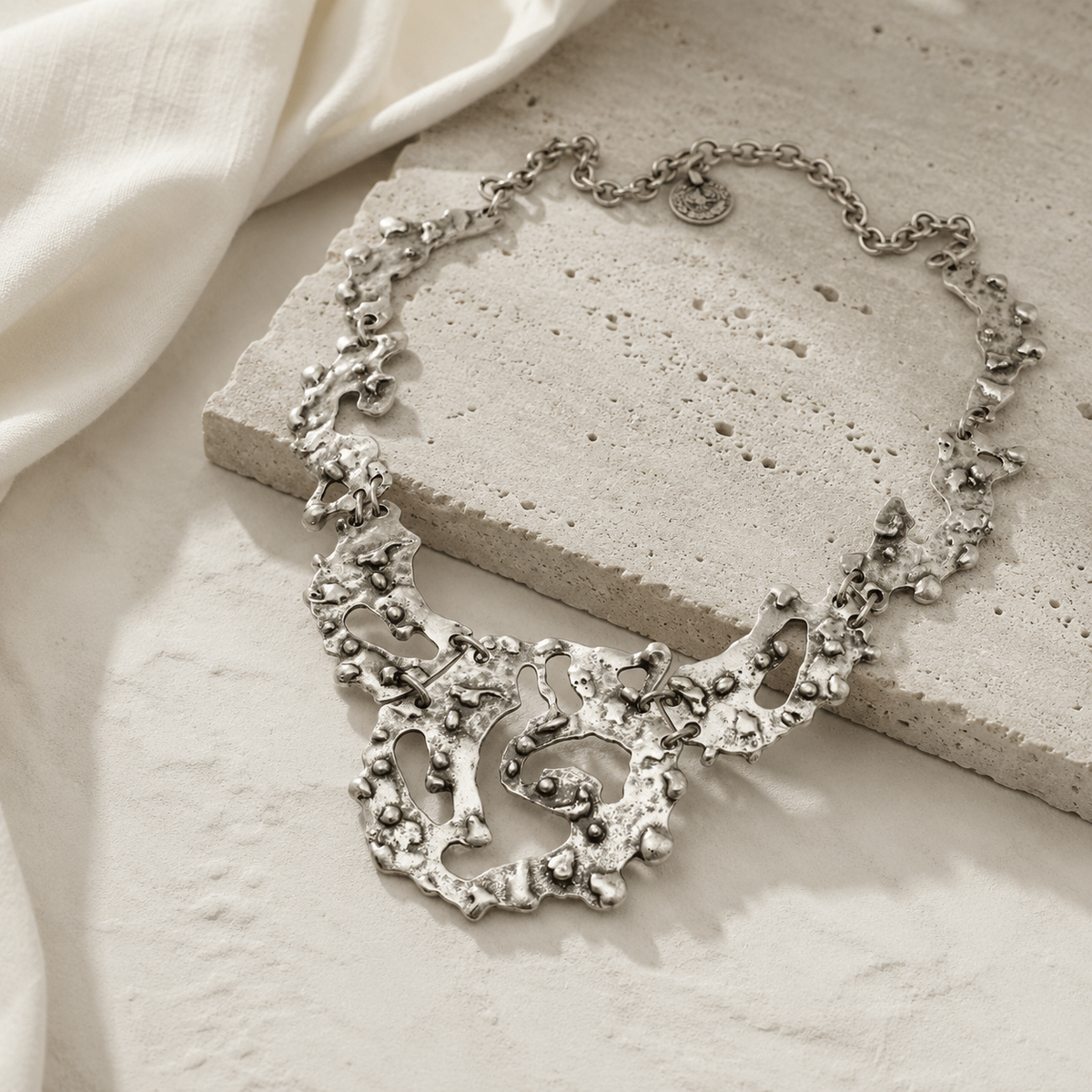 Organic silver-tone statement necklace with an artful, sculptural silhouette.