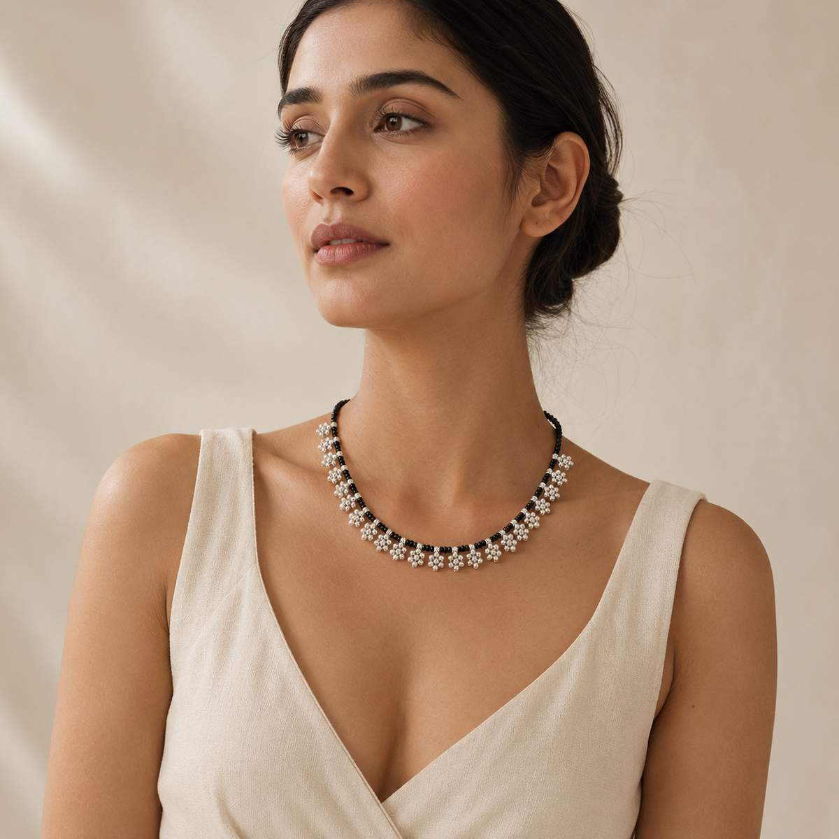 Black bead necklace with silver-tone floral fringe accents.