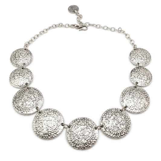 A hammered disc statement necklace with a polished silver-tone finish.