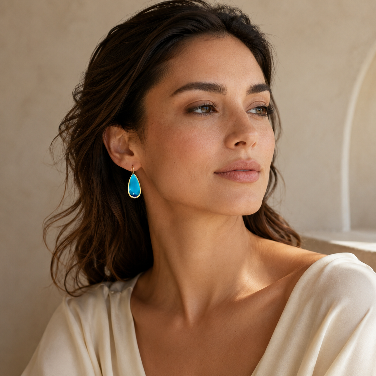 Pair of blue faceted drop earrings with a warm gold finish.