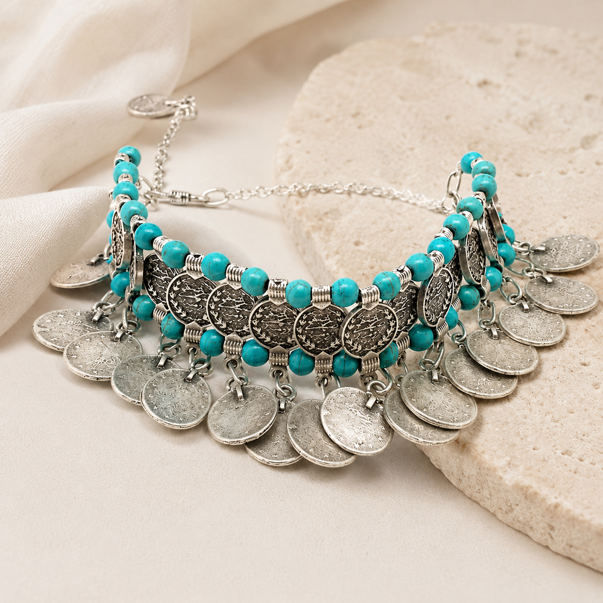 Angled view of a turquoise bead choker with silver-tone coin fringe.