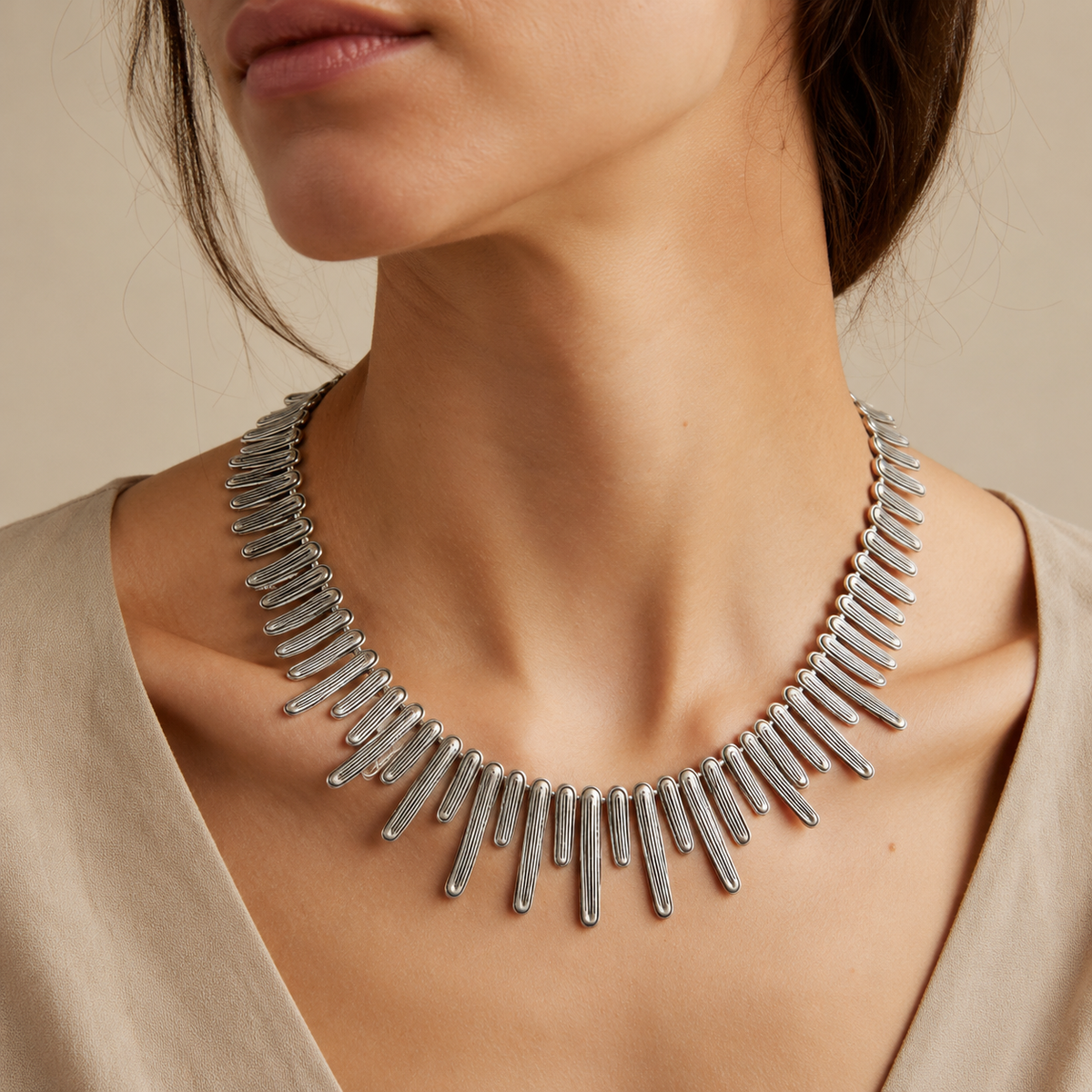 Silver-tone collar necklace shown from above on a white background.