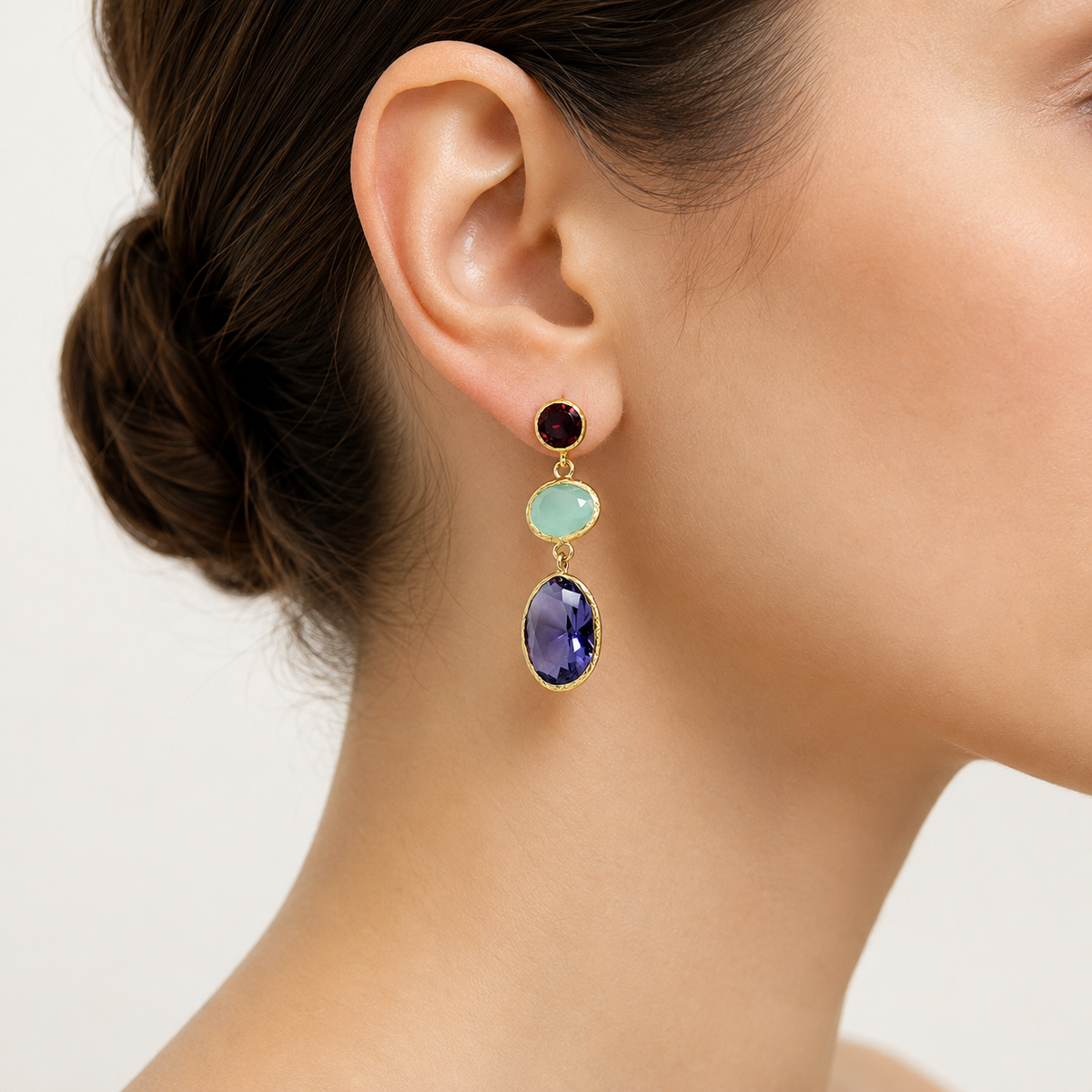 Pair of triple drop earrings with colorful faceted stones and a gold-plated frame.
