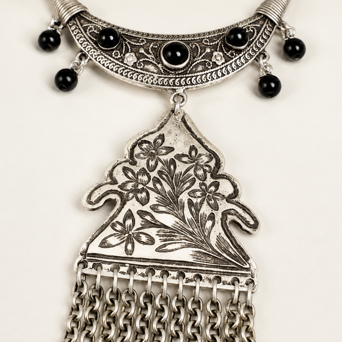 Close view of the floral pendant and black bead accents.