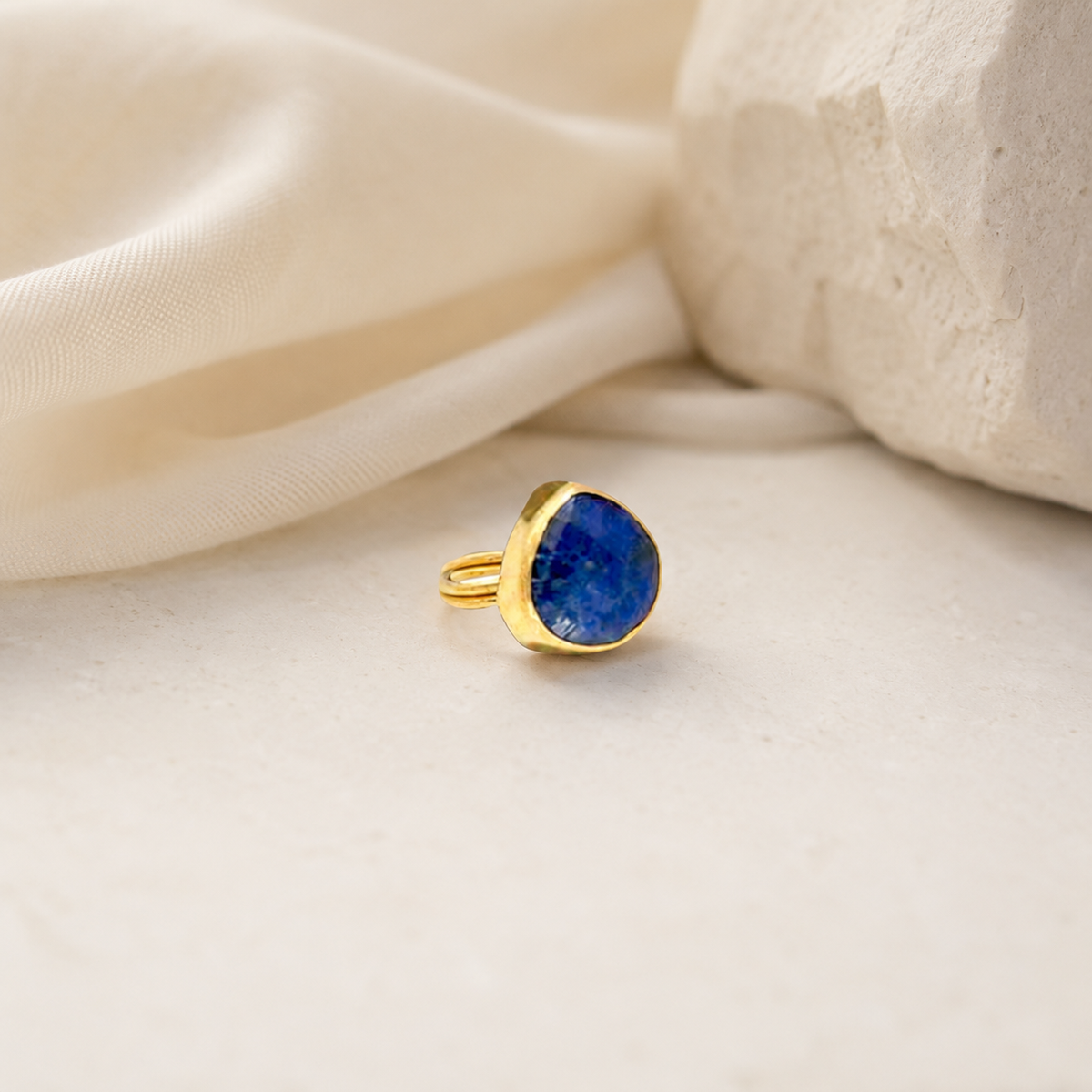 Minimalist gold-plated ring with a blue teardrop stone.