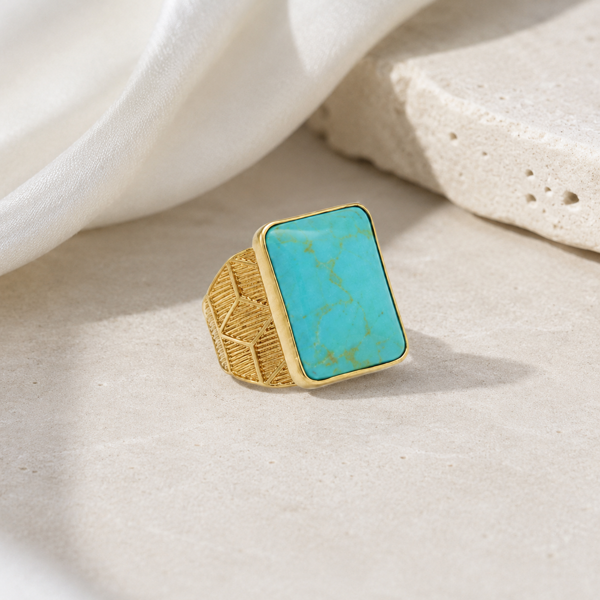 Gold-plated statement ring with a square turquoise center stone.