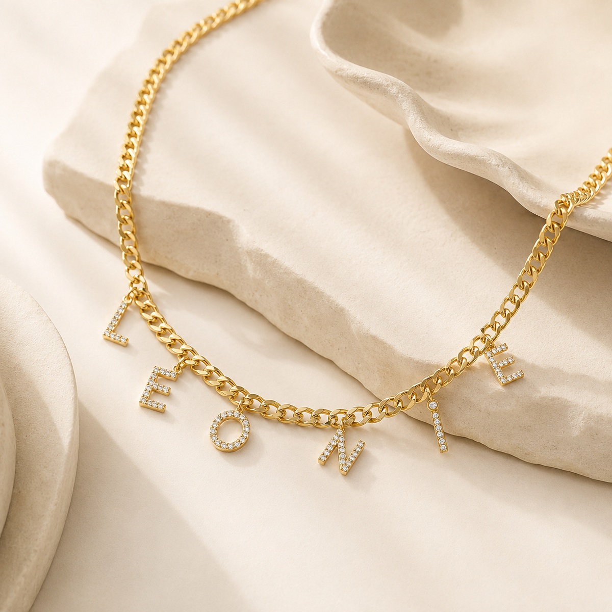 Angled view of a personalized CZ letter necklace on a curb chain.