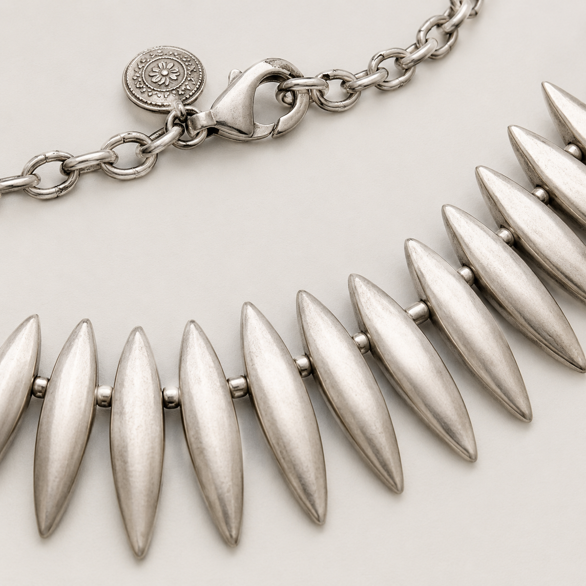 Close view of the silver-tone leaf spike details and clasp.