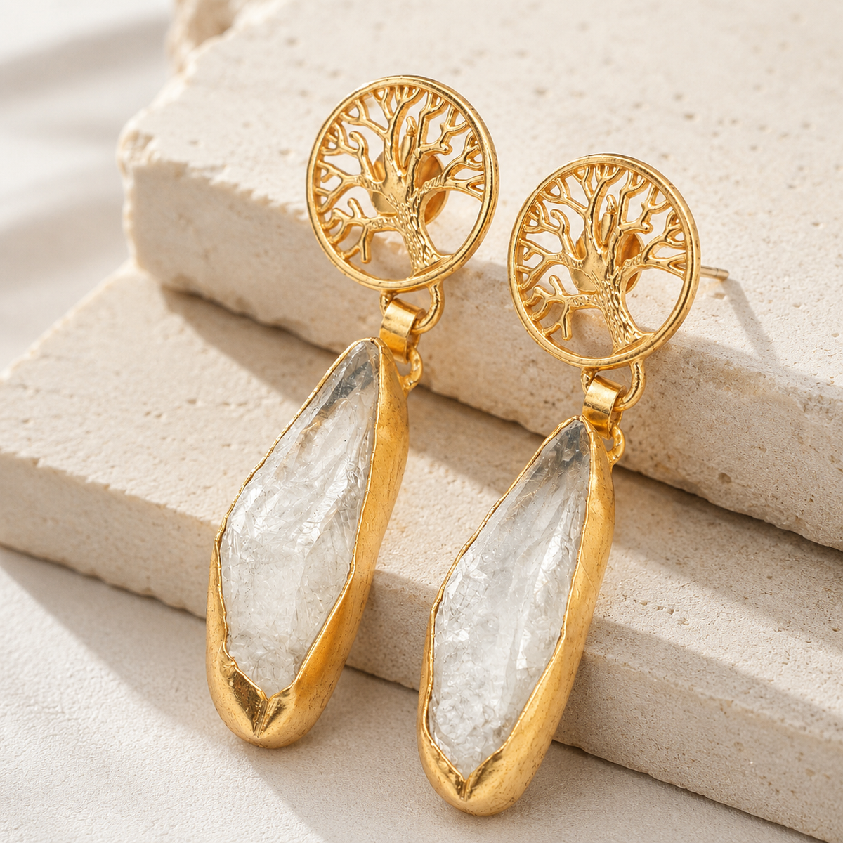 Side angle view of gold-tone tree of life drop earrings.
