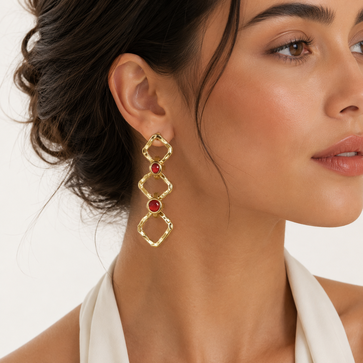 Gold-tone chain drop earrings shown front view with linked geometric shapes and red stone accents.