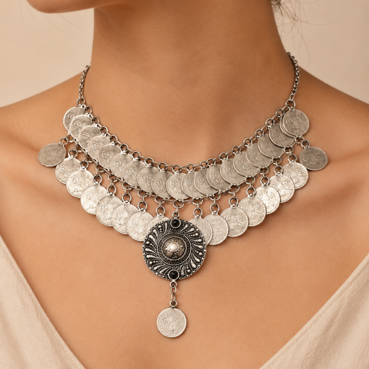 Layered silver-tone coin bib necklace shown on a white background.