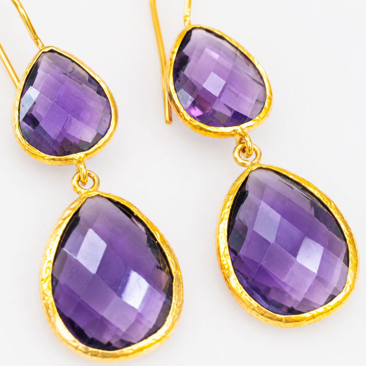 Close-up of faceted amethyst stones framed in gold plating.
