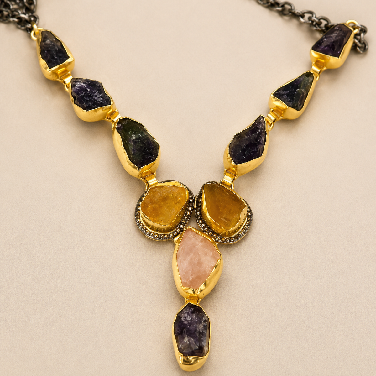 Close view of the mixed gemstone necklace showing the stone details and gold-tone settings.