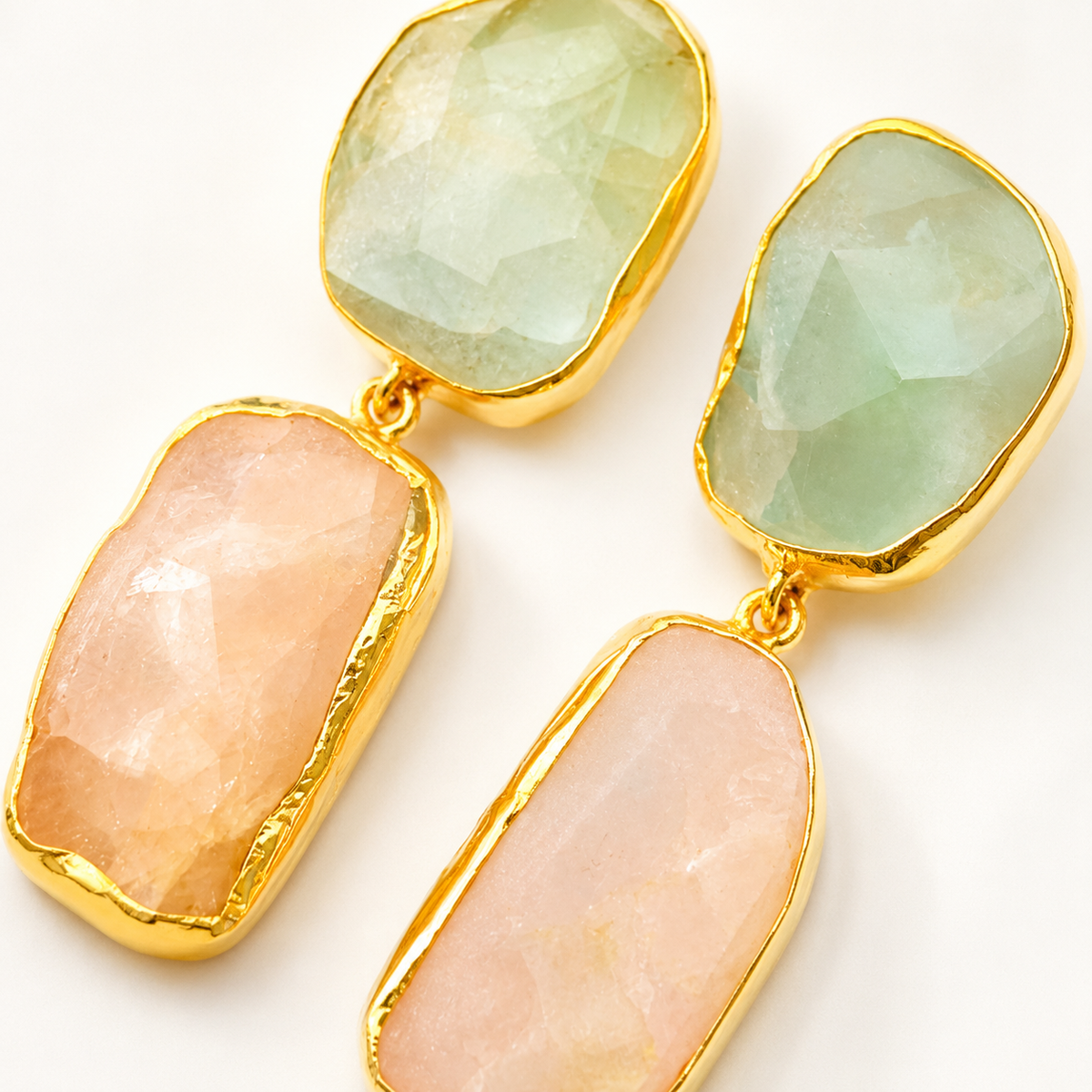 Close-up of rough apatite and rose quartz stones in a gold-plated setting.