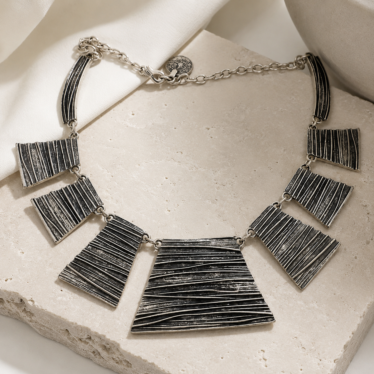 Silver-tone textured panel necklace shown in a clean product view.