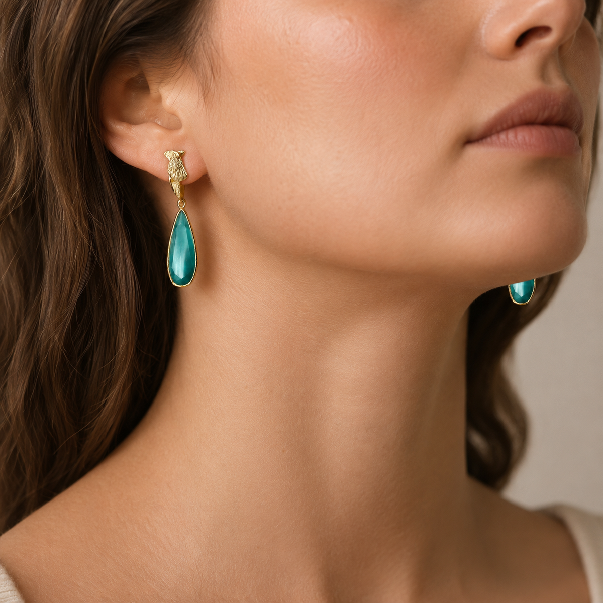 Turquoise and gold drop earrings with a faceted teardrop shape.