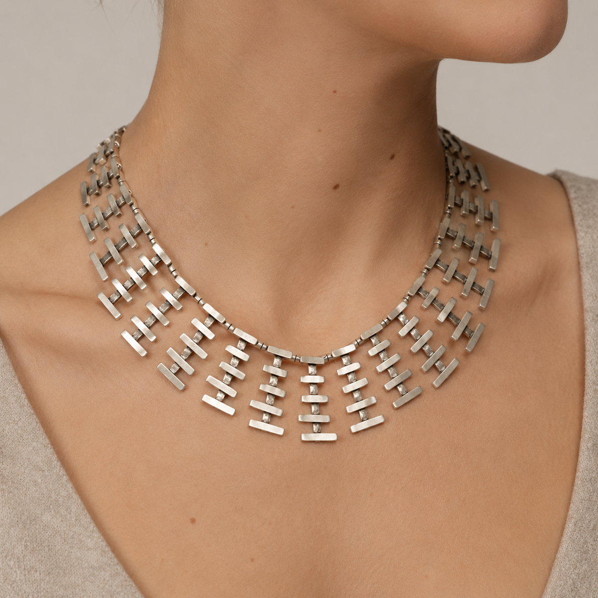 Silver-tone bar fringe necklace shown from above on a white background.