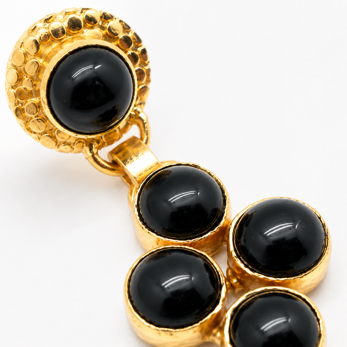 Close view of the gold-plated setting and glossy black stones on the earrings.