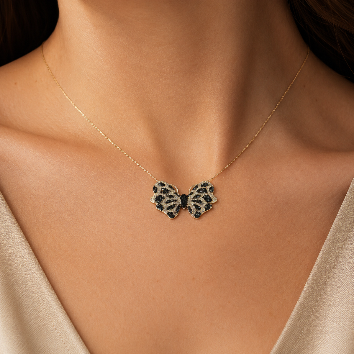 Gold-tone butterfly pendant necklace shown against a white background.