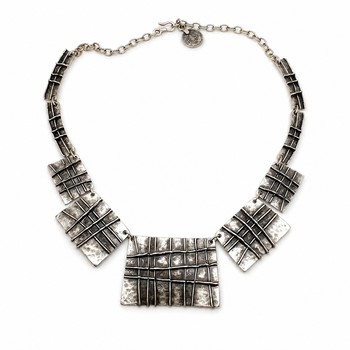 Silver-tone statement necklace with grid-textured plaque pendants.