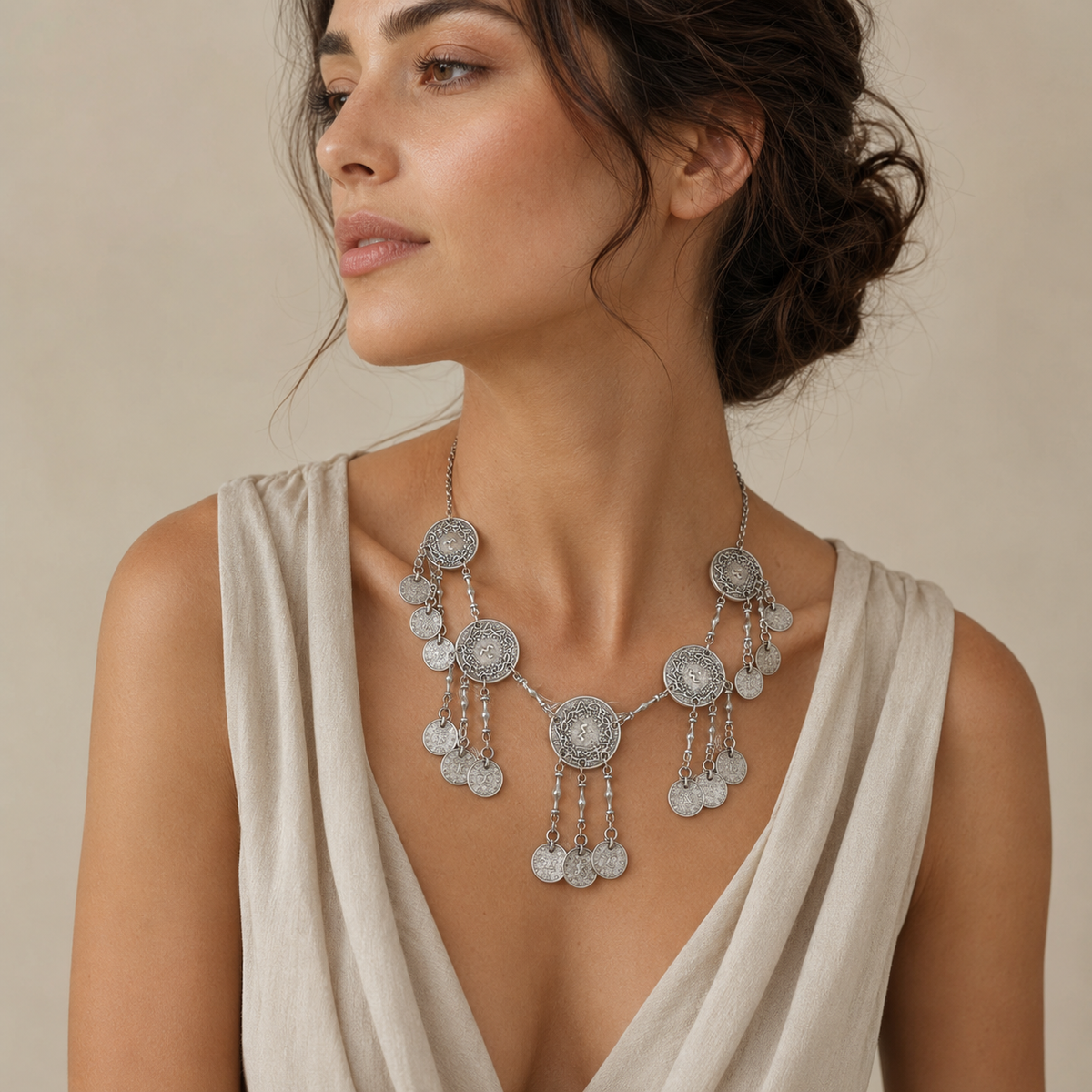 Statement necklace with textured silver-tone coin discs and fringe accents.