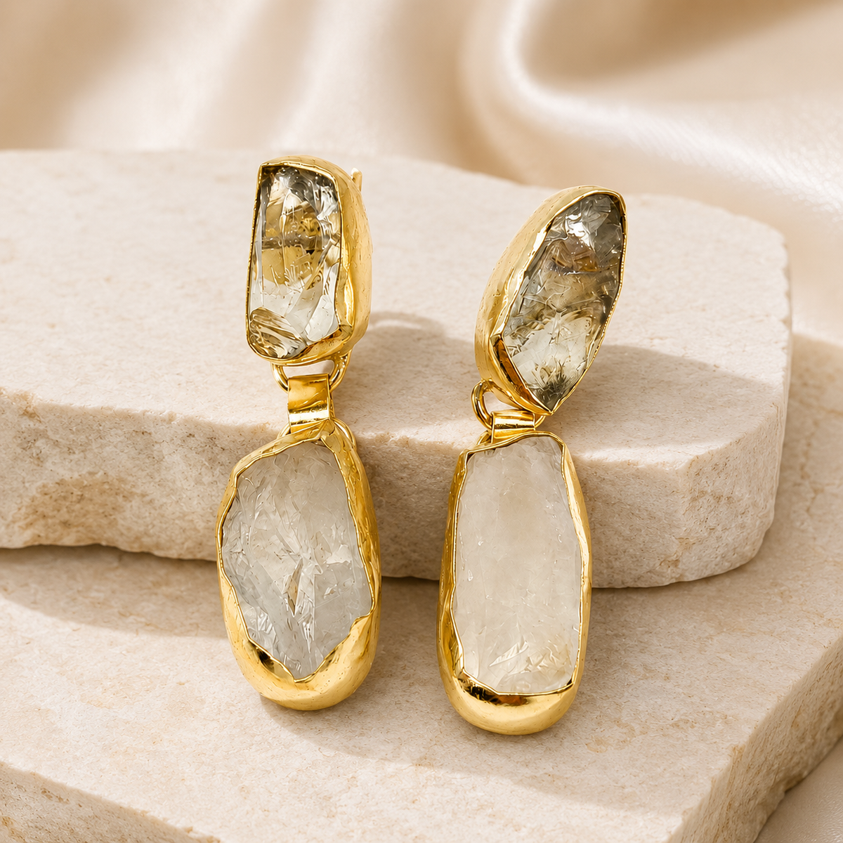 Angle view of gold-plated drop earrings with round pearl-inspired accents.