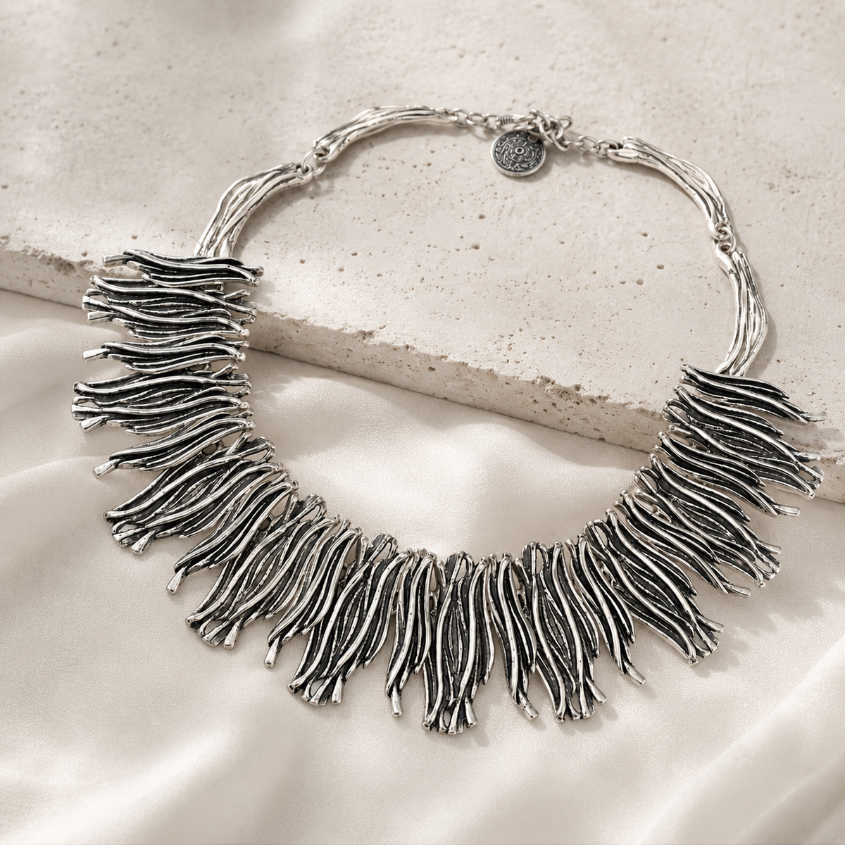 Silver-tone fringe collar necklace with a sculptural layered silhouette.