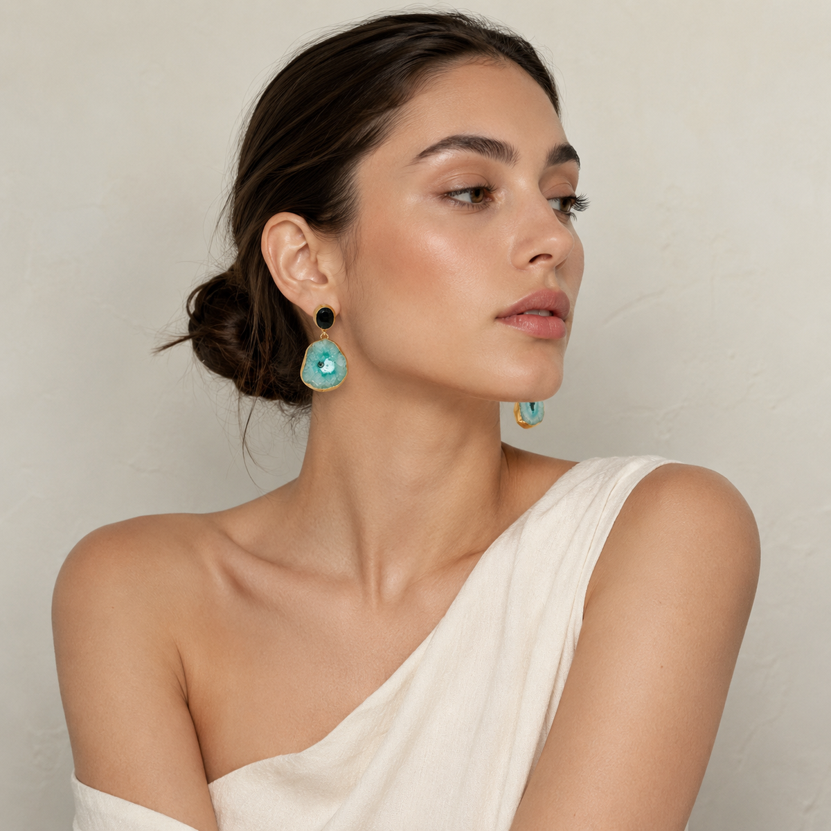 Gold-plated drop earrings with contrasting black and pale green stone details.