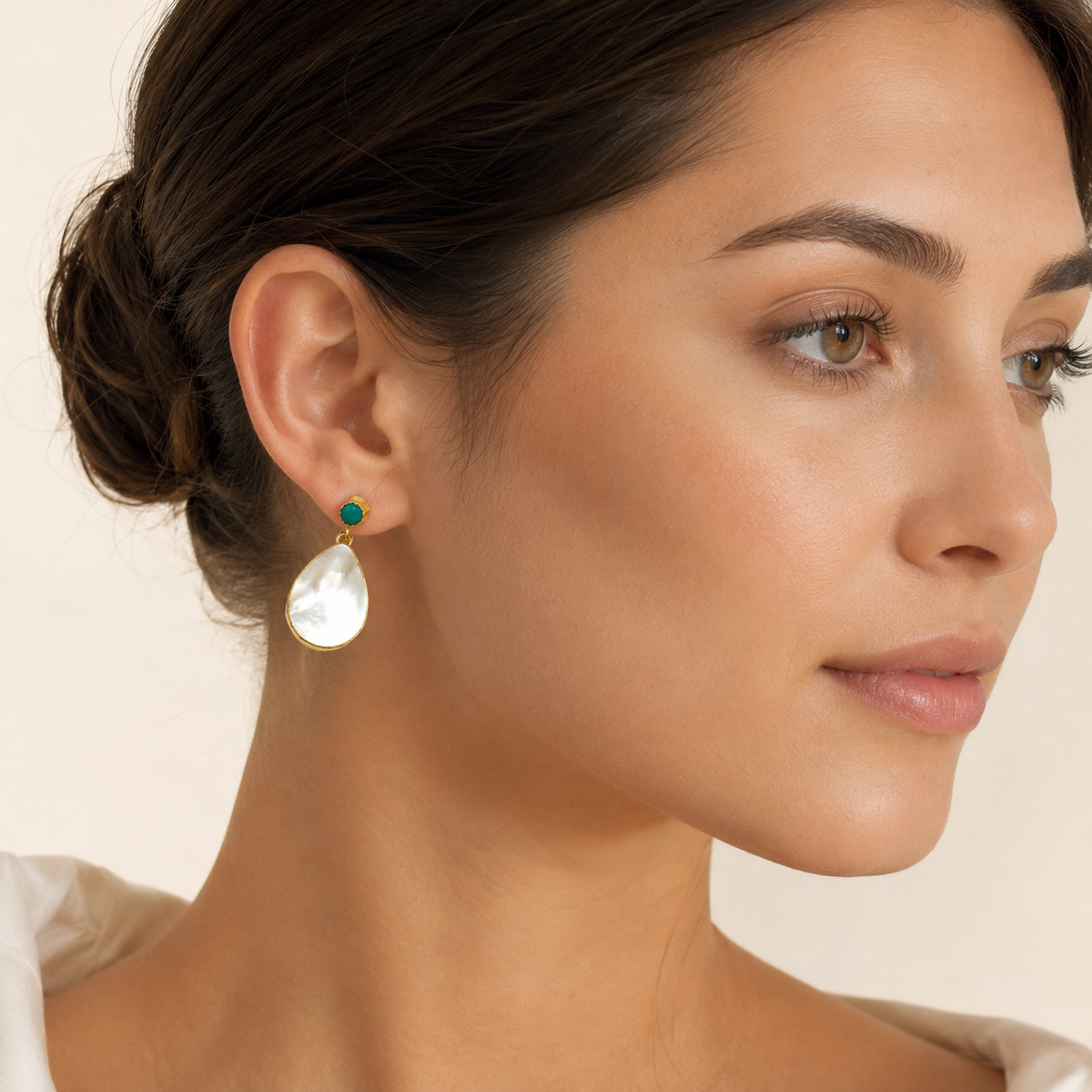 Pair of mother of pearl drop earrings with gold plated settings and turquoise tops.